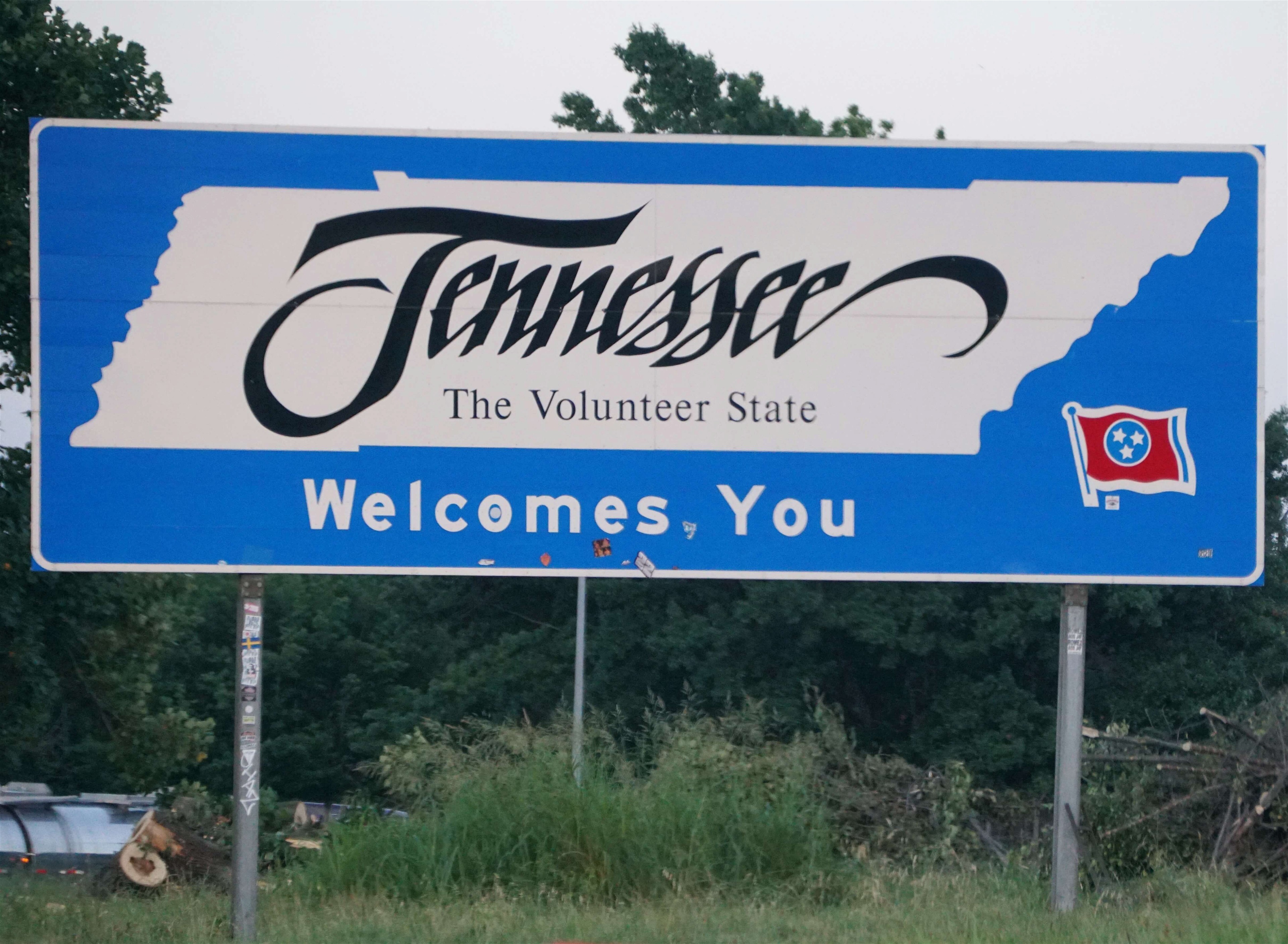 State of Tennessee welcome sign in front of green trees