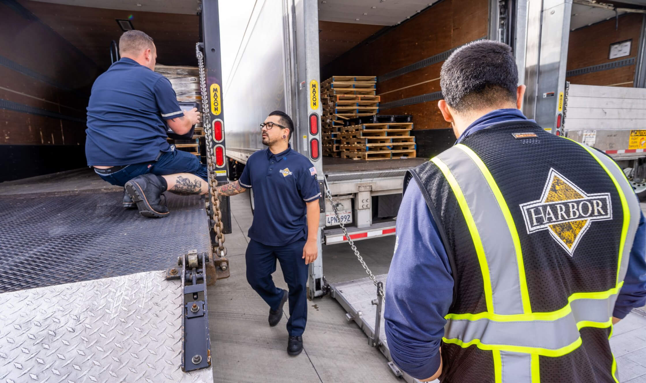 RBD Harbor employees standing behind trucks with pallets inside them