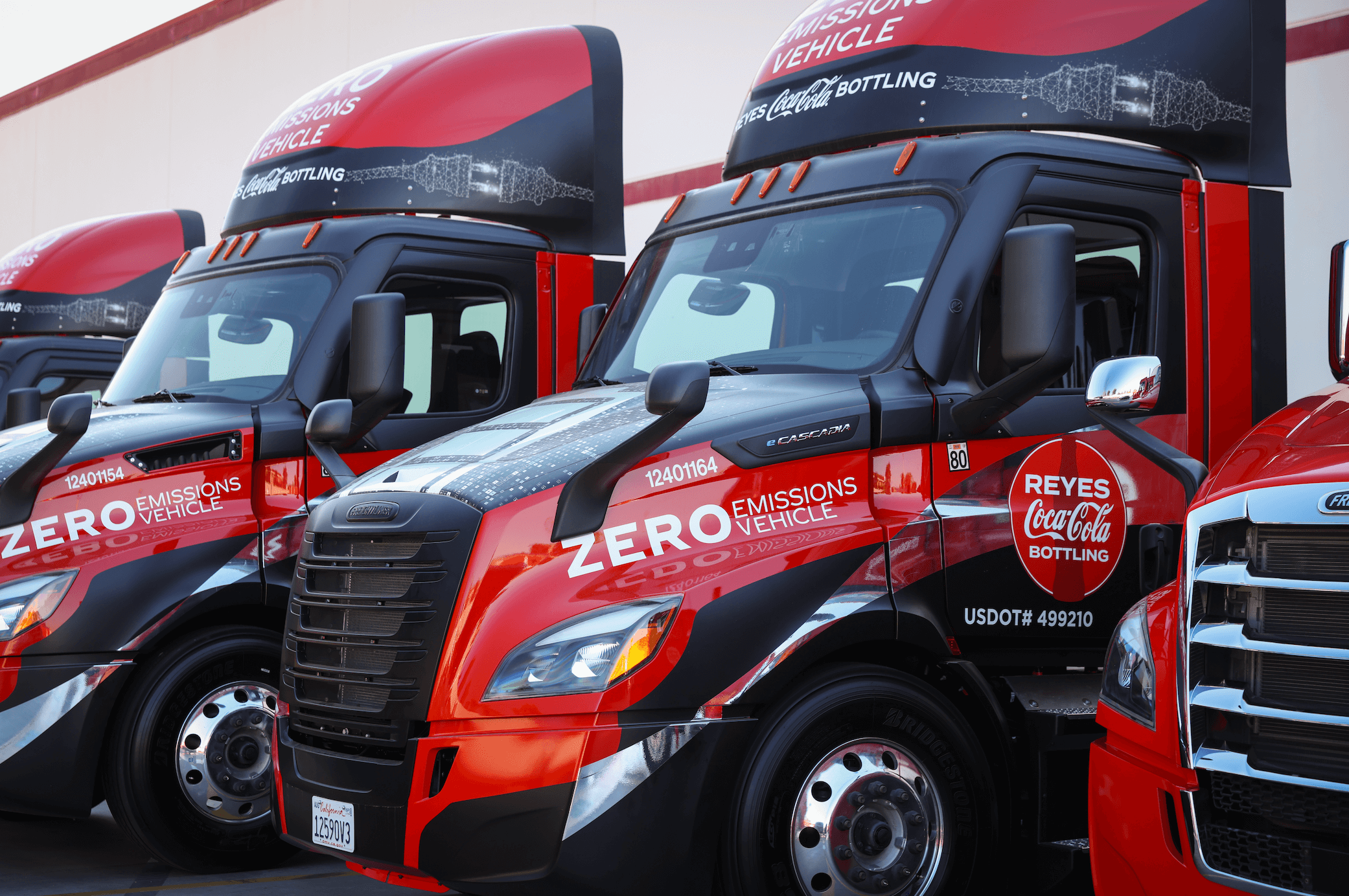 Reyes Coca-Cola Bottling zero emission trucks in a row.