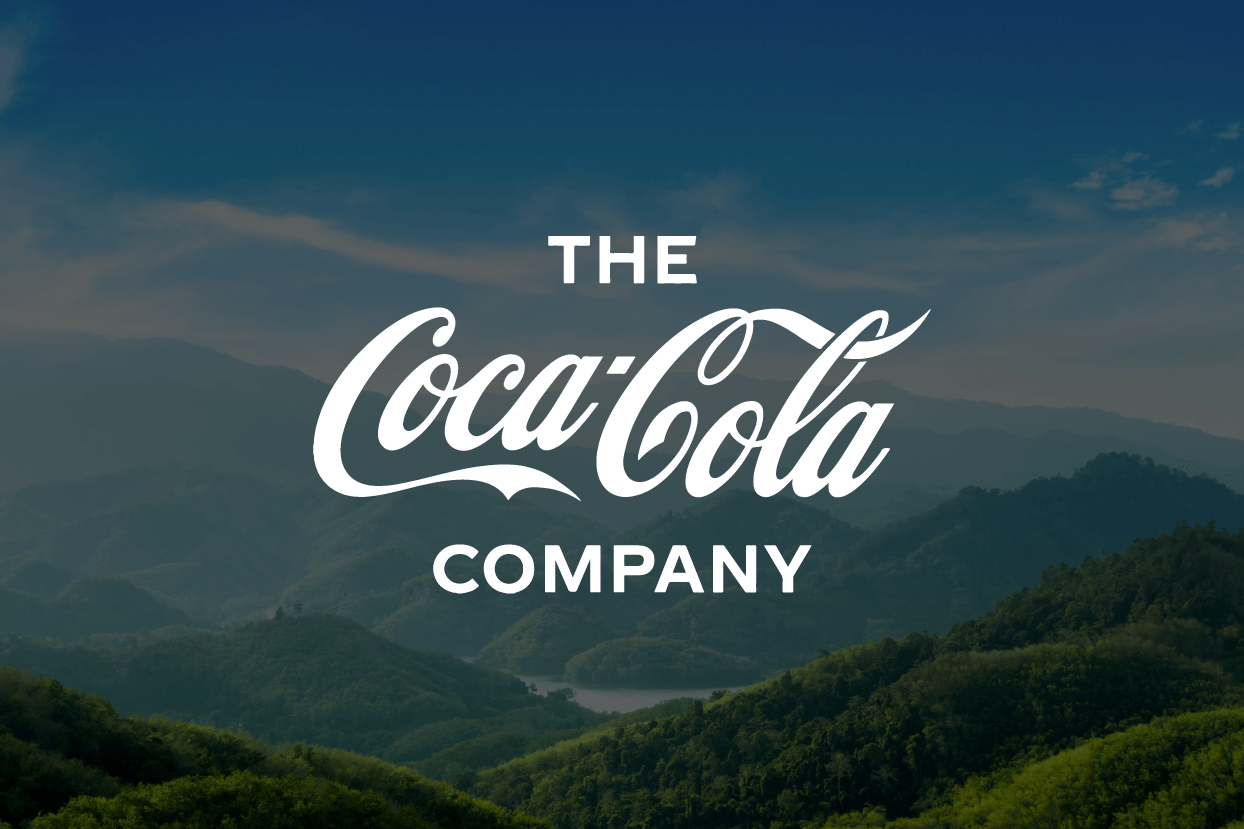 The Coca-Cola Company logo in front of mountains.