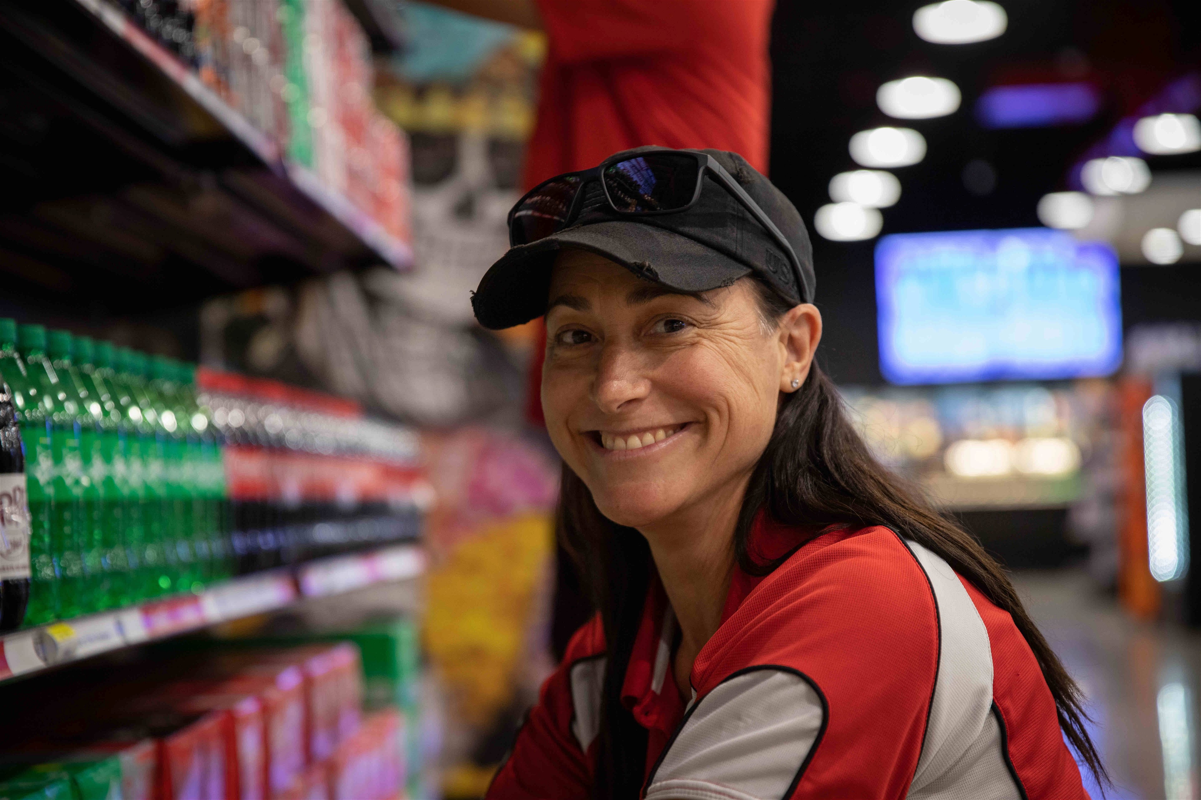 Smiling girl next to the Coca-Cola shelf